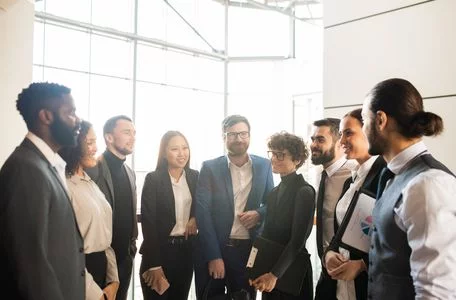 group of employees talking to each other in the office while standing in a semicircle