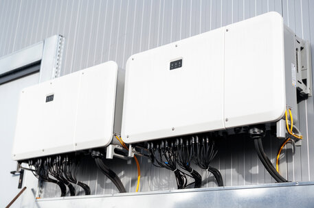 Close view of supporting systems for solar panels located on a manufacturing building , lots of connected wires. Ecology thematics