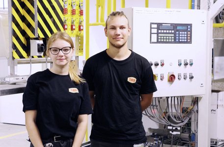 two TIGER apprentices standing in front of a TIGER production machine