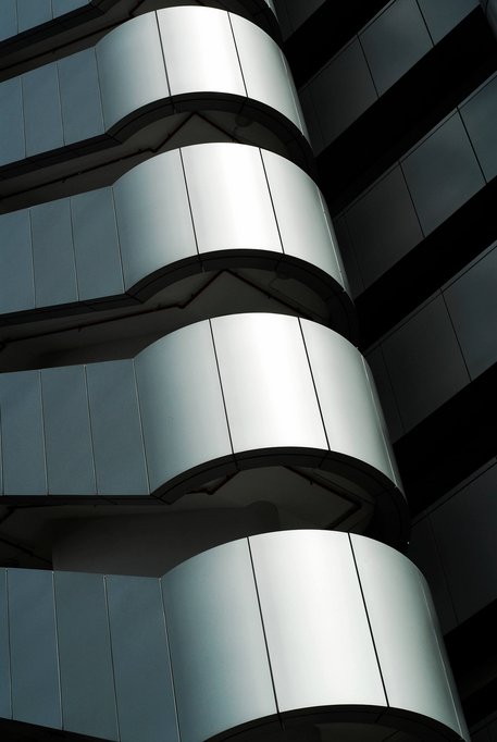 runde Ecke einer mit Eloxalsilber beschichteten Gebäudefassade